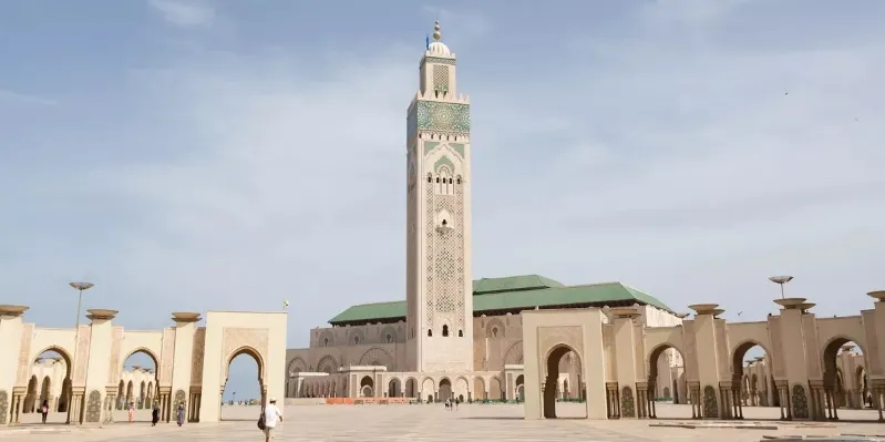  The majestic Islamic mosque in Casablanca, Morocco, featuring beautiful minarets and detailed design against a clear sky. MOROCCO TRIP FROM SPAIN