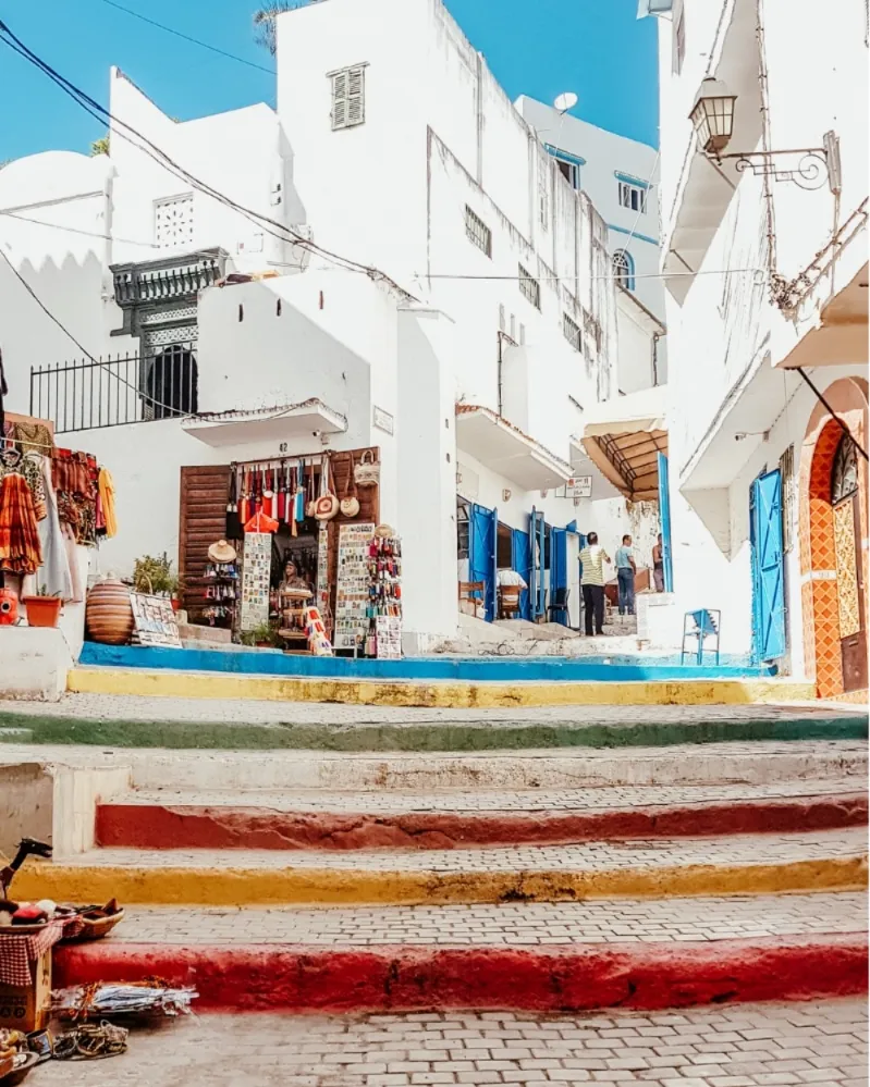  A vibrant street scene in a town, featuring colorful buildings and lively atmosphere, inviting exploration and enjoyment in Morocco trips from Spain 