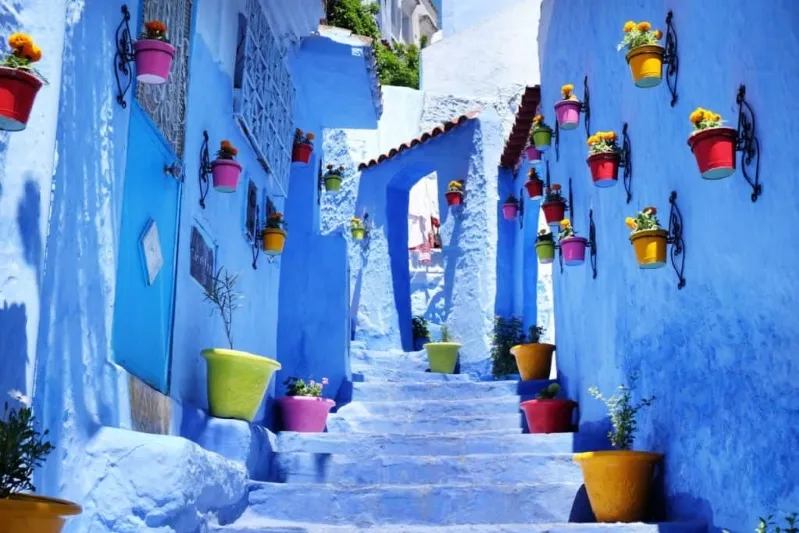 A scenic view of Chefchaouen, Morocco, showcasing its iconic blue buildings and mountainous backdrop.While visit chefchaouen