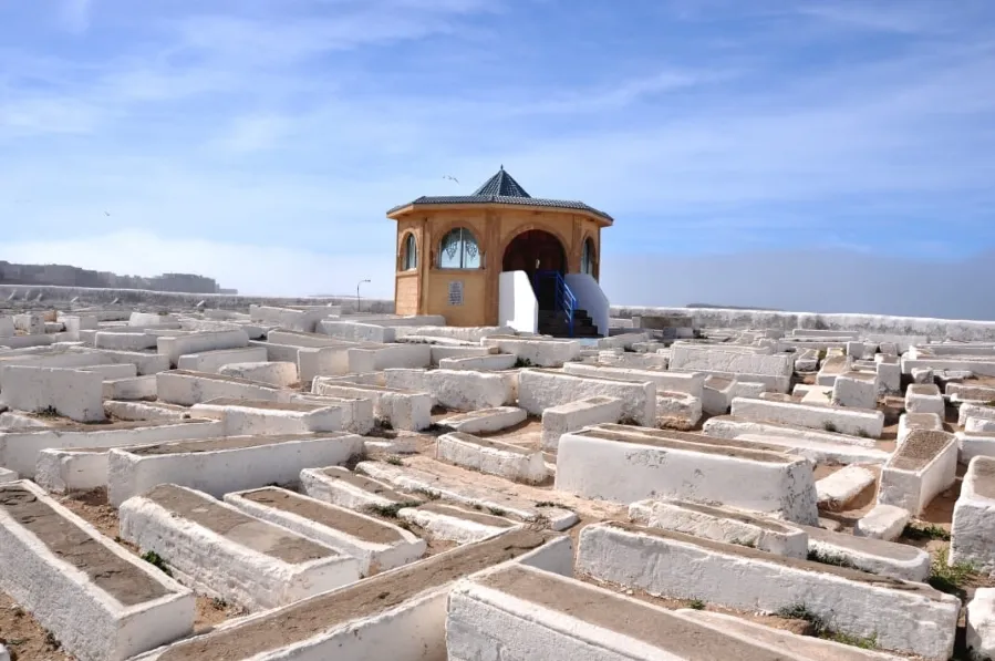 man is positioned in front of a maze, with a gazebo in view, representing a moment of reflection and decision-making While MOROCCAN JEWISH HERITAGE