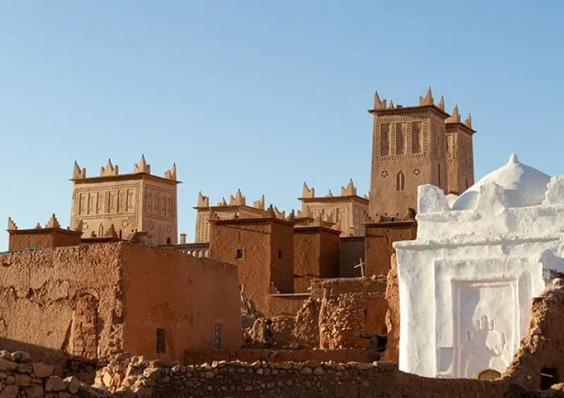  A colorful Moroccan city, featuring bright buildings and lively streets that embody the rich cultural heritage of the region ,while luxury morocco desert tour