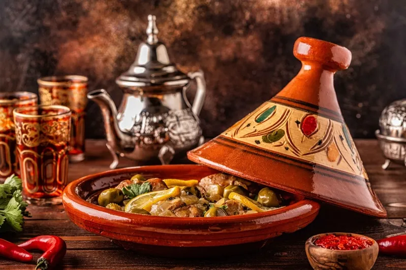  A vibrant display of Moroccan cuisine featuring vegetables and spices arranged on a rustic wooden table.While travel trips