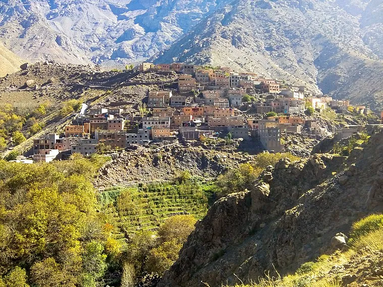 A picturesque mountain village nestled among peaks, showcasing a stunning mountain range in the background Tizi Oussem Day Trip