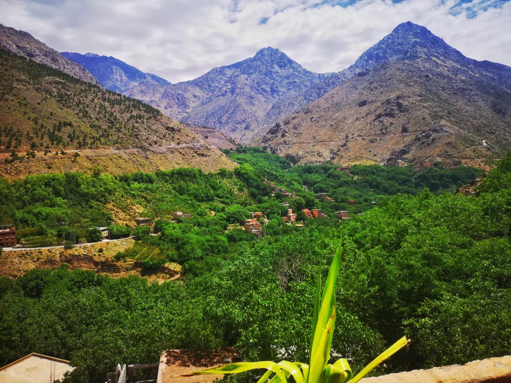 A scenic view of mountains and a lush valley as seen from a balcony, showcasing nature's beauty and tranquility Full-day Trip to Imlil Valley and the Toubkal From Marrakech