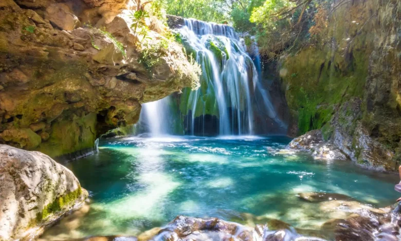 Stunning waterfalls cascade through a gorge, showcasing breathtaking natural beauty in a serene landscape. Chefchaouen & Akchour Waterfalls Day Trip from Fes