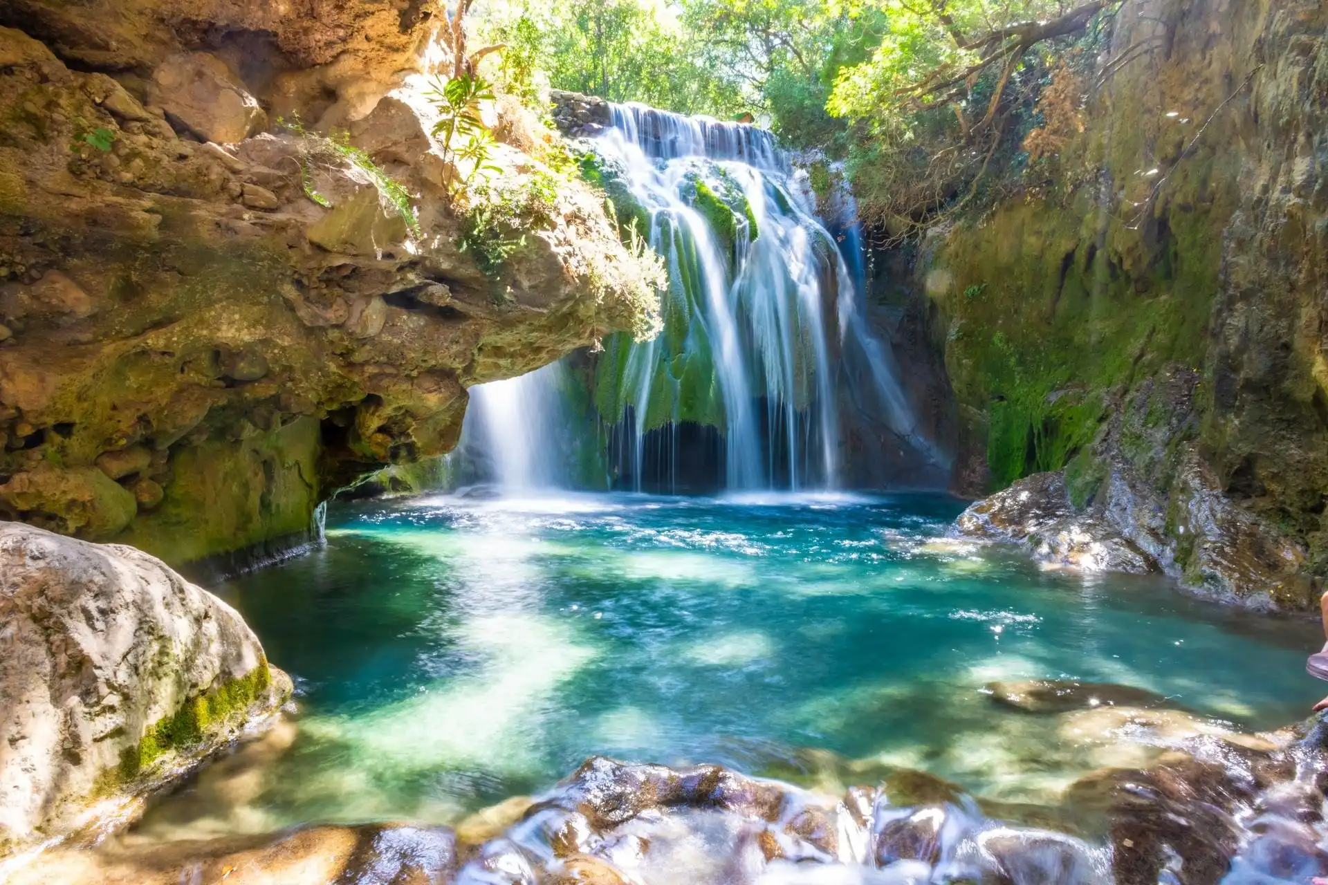 Stunning waterfalls cascade through a gorge, showcasing breathtaking natural beauty in a serene landscape. Chefchaouen & Akchour Waterfalls Day Trip from Fes