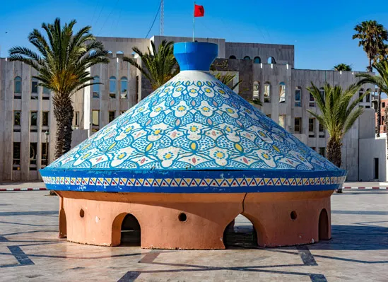 A blue and white building featuring a prominent dome on top, set against a clear sky.une journée à Safi