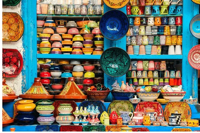 Colorful pottery and various decorative items are showcased in a bright window display.une journée à Safi