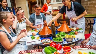 A diverse group of people enjoying a meal together around a table filled with various dishes and drinks. Moroccan Cooking Class