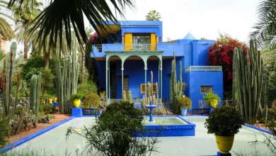 A blue house featuring vibrant yellow and green accents on its exterior. Majorelle Garden & Yves Saint Laurent Museum