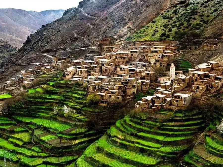  A scenic mountain village featuring lush terraces and traditional architecture nestled among the peaks.6 Days Ouarzazate to Fes via Desert & Atlas Mountains