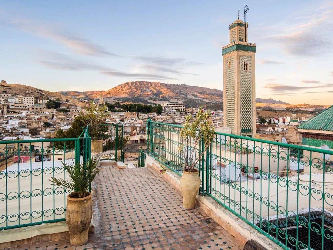 View from a Moroccan mosque roof, showcasing traditional architecture and surrounding landscape under a clear blue sky.12 Days Grand Morocco Tour