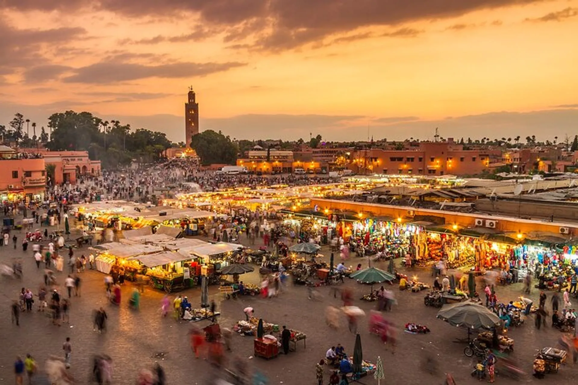 Marrakech skyline at sunset, showcasing vibrant colors and silhouettes of buildings against a fading light backdrop. Photography Tour in Marrakech