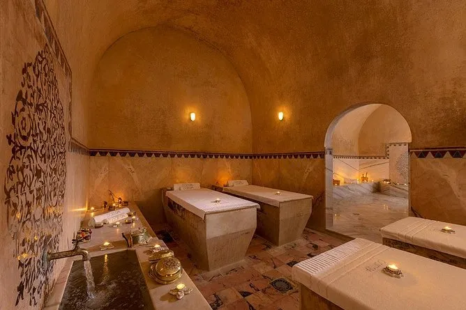 A spacious room featuring two sinks and several lit candles, creating a warm and inviting atmosphere.
