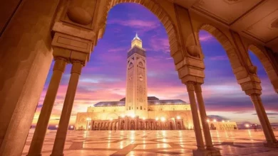 A mosque illuminated by warm sunset light, showcasing its architectural details against a colorful sky.12 Days Grand Morocco Tour