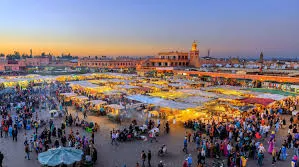 Marrakech skyline at sunset, showcasing vibrant colors and silhouettes of buildings against a fading sky.