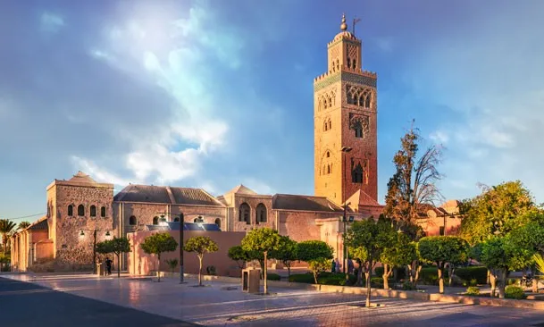 Marrakech, Morocco, showcasing vibrant markets, historic architecture, and the Atlas Mountains in the background. 