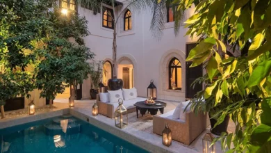 A serene courtyard featuring a pool surrounded by a spacious patio area for relaxation and leisure activities. Day at a Luxury Pool & Garden Resort