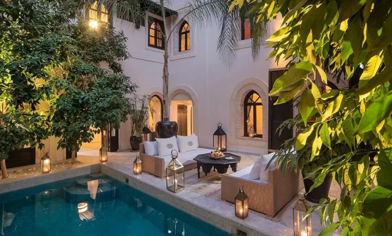 A serene courtyard featuring a pool surrounded by a spacious patio area for relaxation and leisure activities. Day at a Luxury Pool & Garden Resort