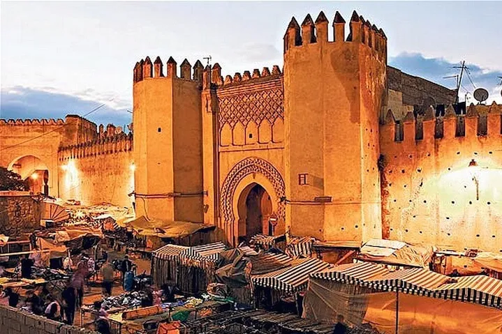 Old city of Marrakech, Morocco, showcasing vibrant markets, historic architecture, and bustling streets filled with people.