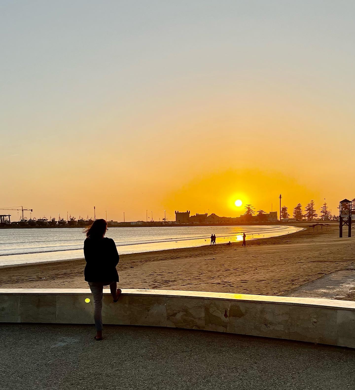 Essaouira ramparts at sunset overlooking Atlantic Ocean and port with fishing boats