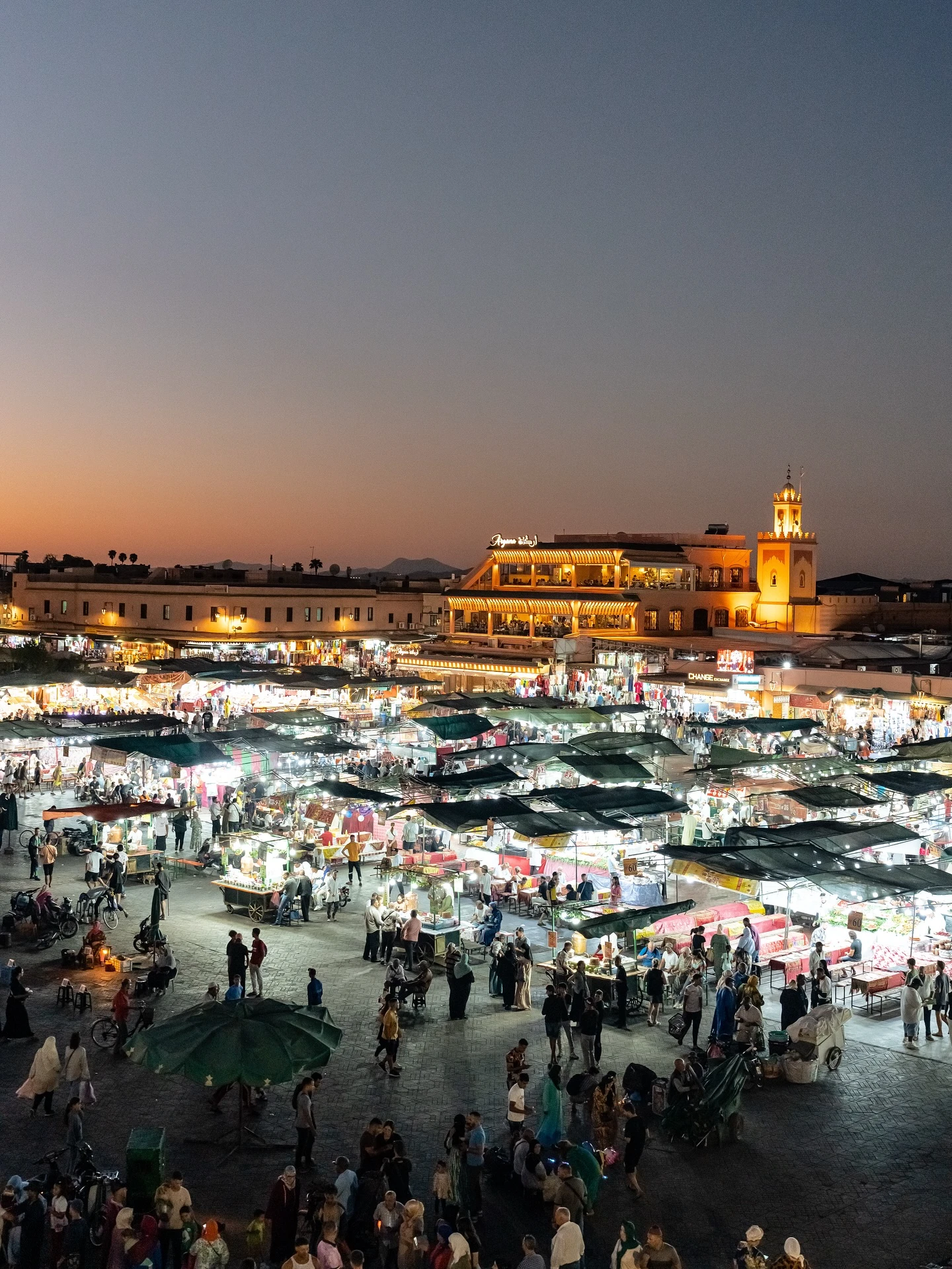 Jemaa el-Fnaa square at sunset in Marrakech with food stalls, musicians and crowds