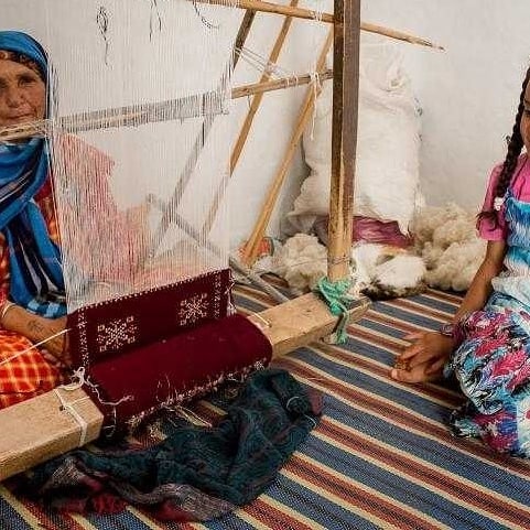 Berber artisan weaving a traditional Moroccan carpet
