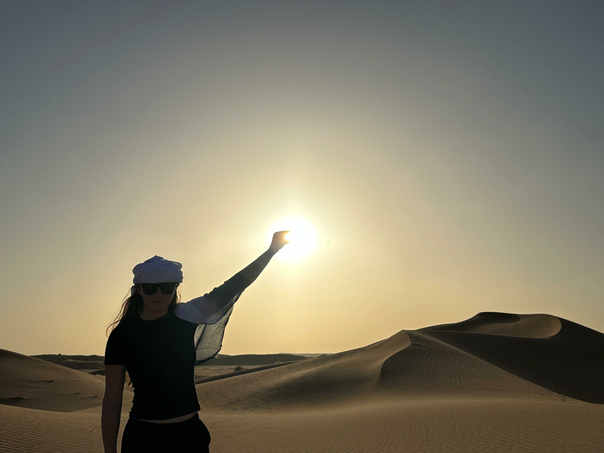 Woman watching sunset over Merzouga dunes Morocco