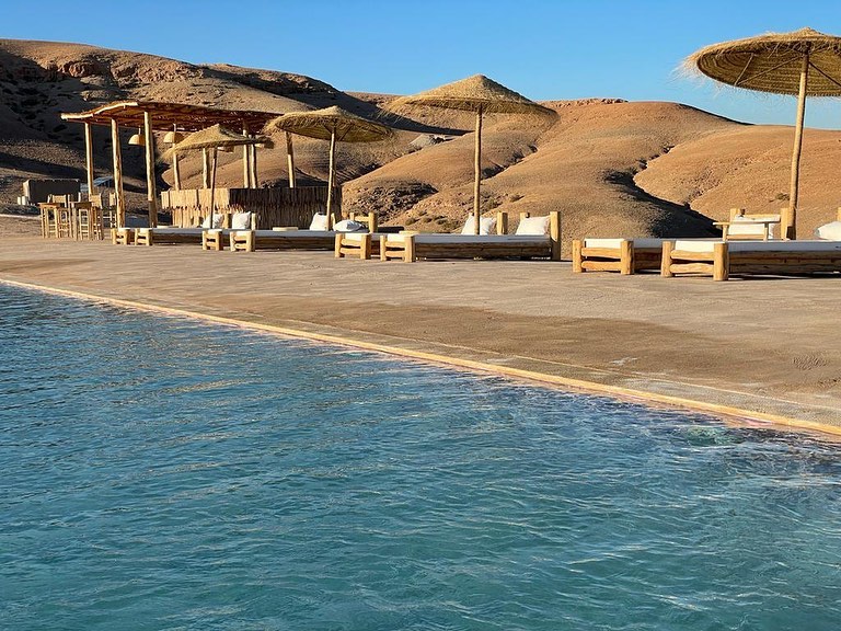 Infinity pool at an Agafay desert luxury camp overlooking the rocky stone plateau