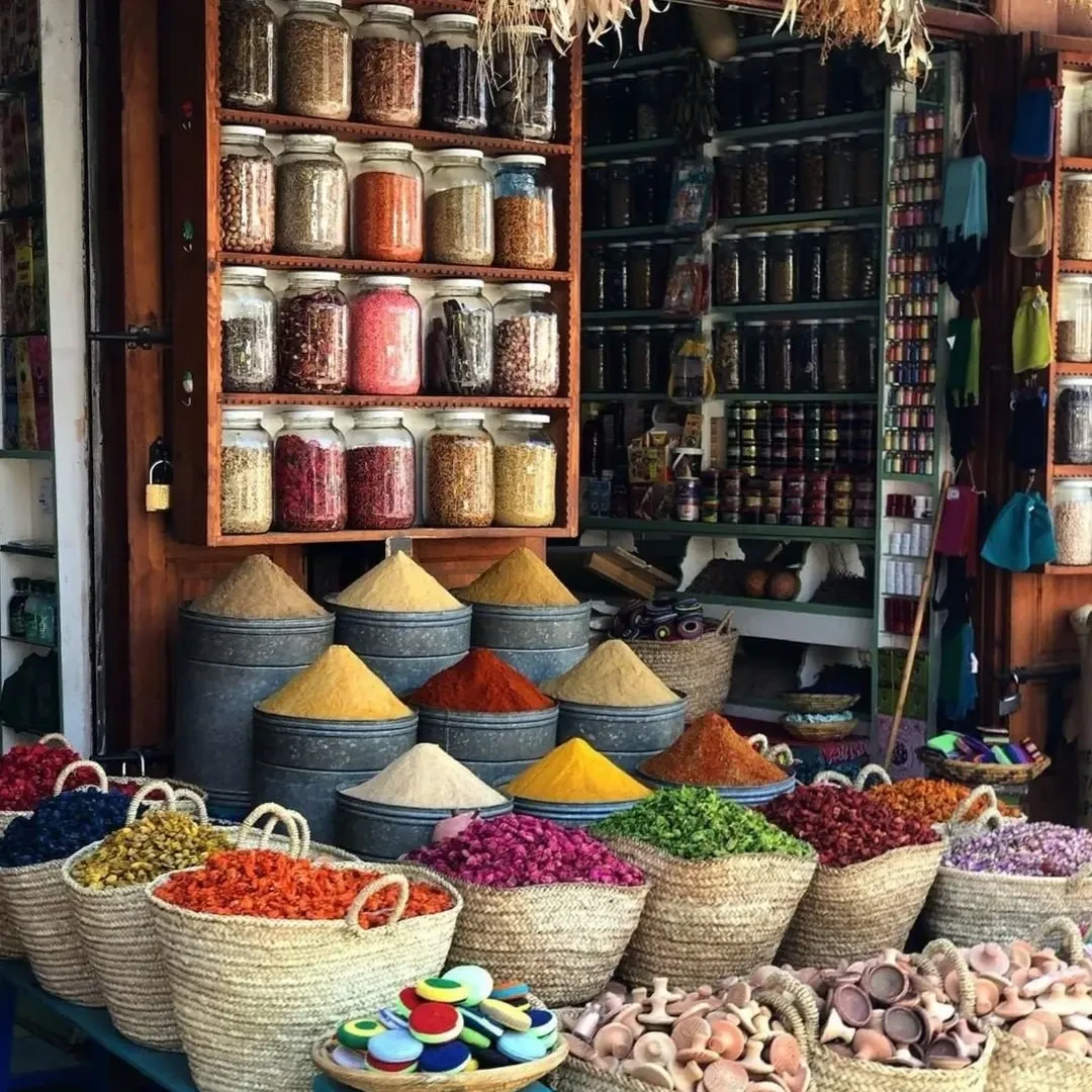 Moroccan spice market with colorful spice piles — cumin, turmeric, saffron, ras el hanout