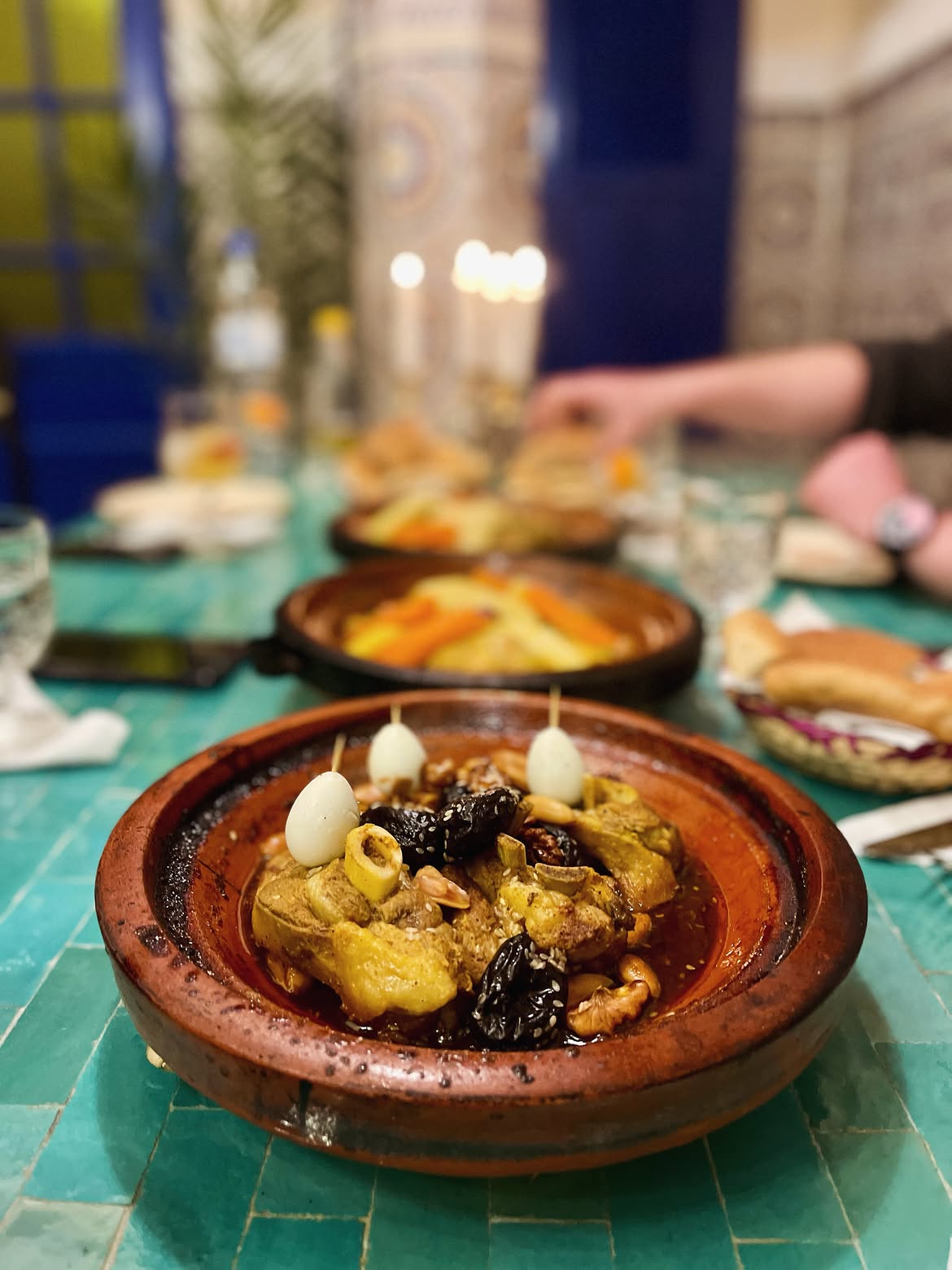 Traditional Moroccan tagine served with bread on a shared table