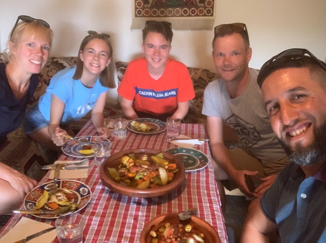 Family sharing a traditional Moroccan meal together during their tour — a moment of genuine connection