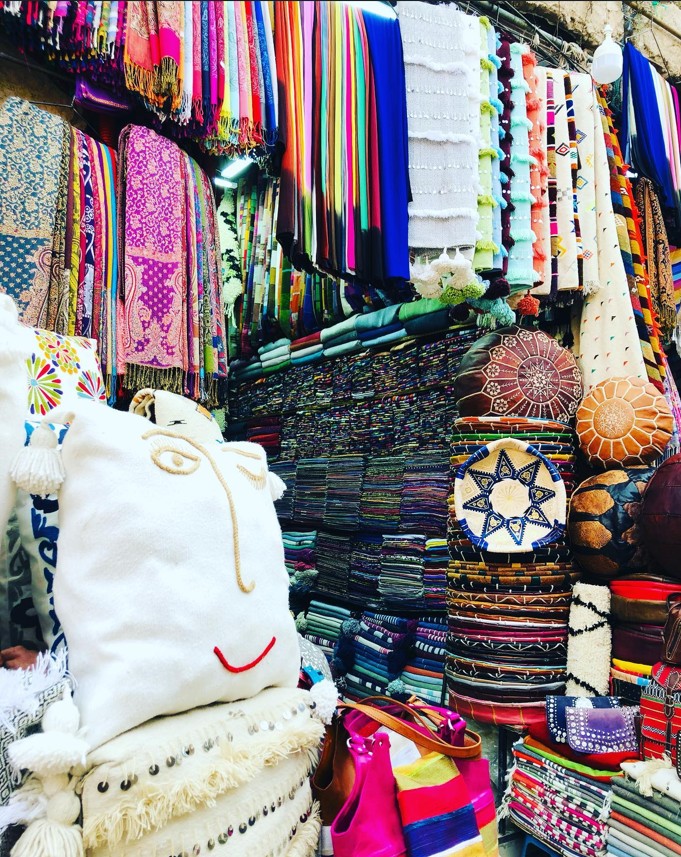 Browsing handmade goods with a local vendor in a Moroccan souk