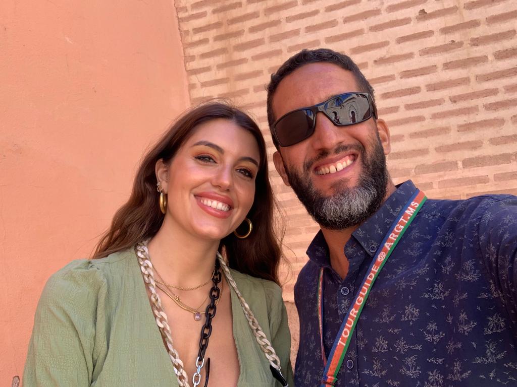 Local tour guide walking with a tourist through the medina of Marrakech