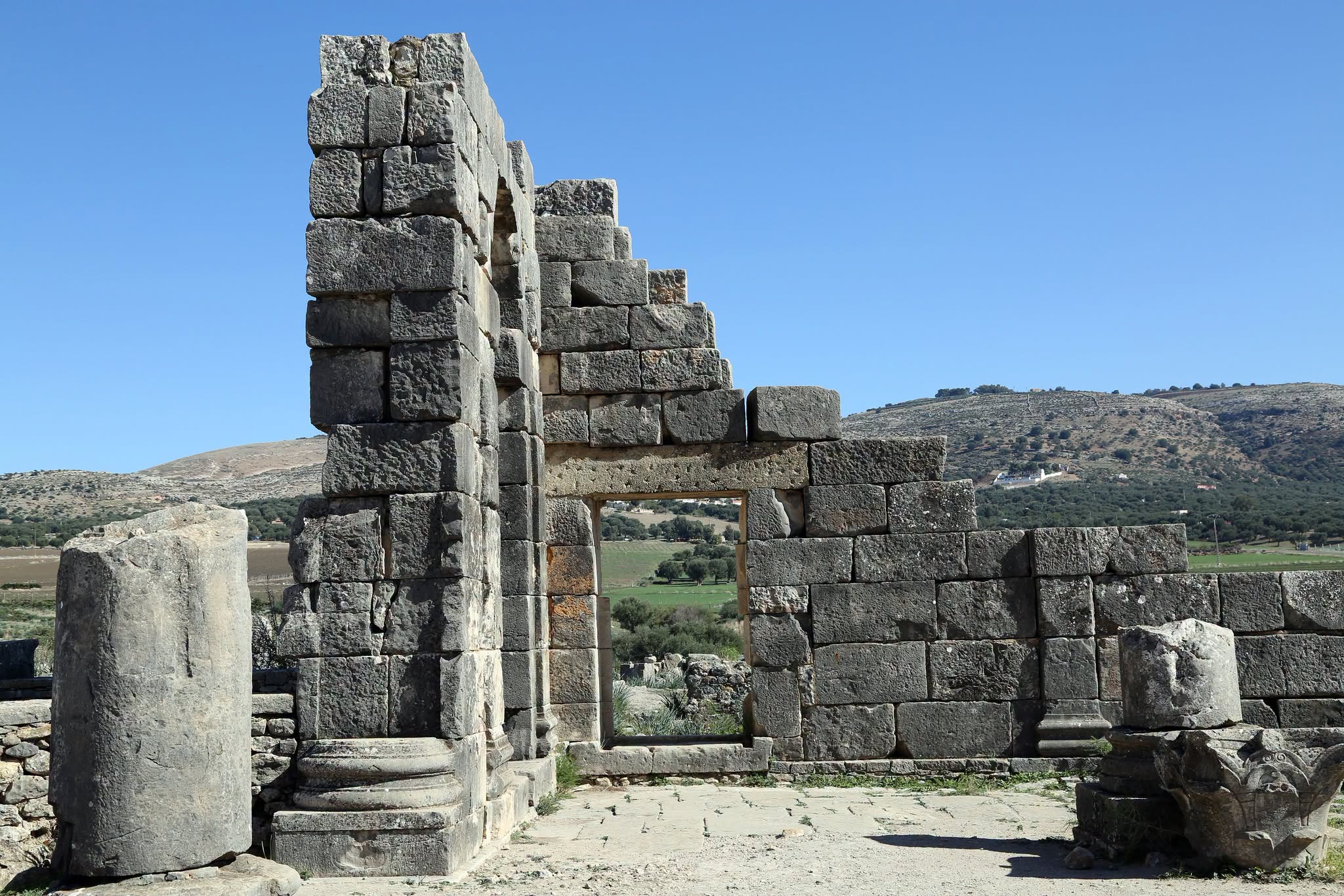 Remains of one of the Roman gates at Volubilis, framing a view of the surrounding hills